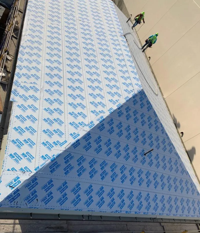 Professional roofers installing underlayment on a metal roof in Clifton Heights